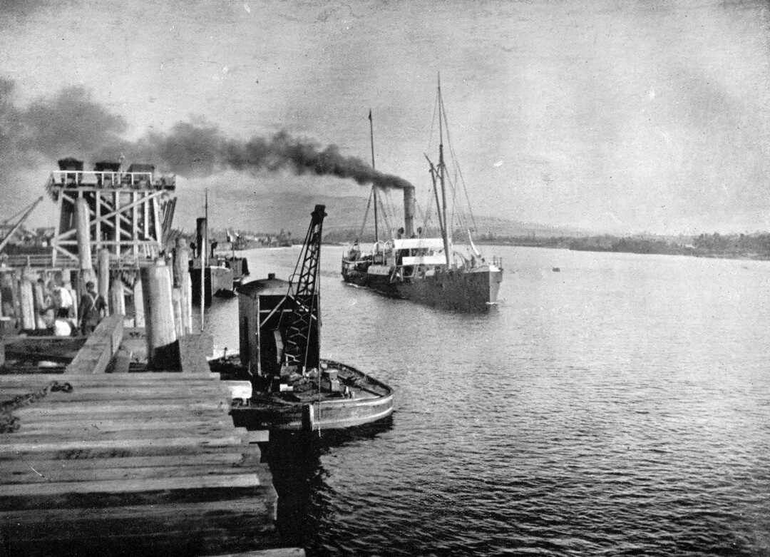 Historic black and white picture of ship coming into the port 