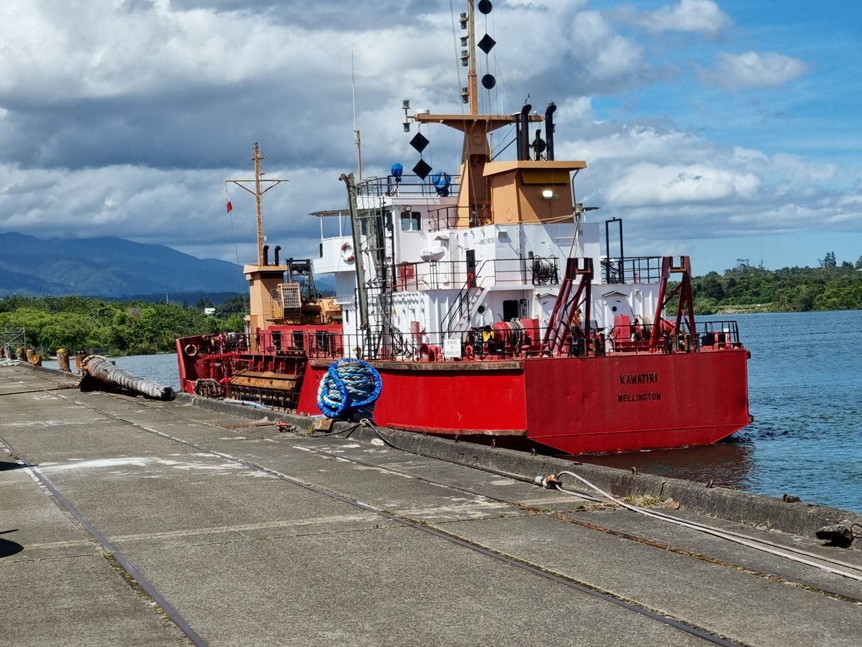 A ship docked on the port with a river in the background