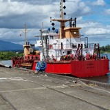 A ship docked on the port with a river in the background