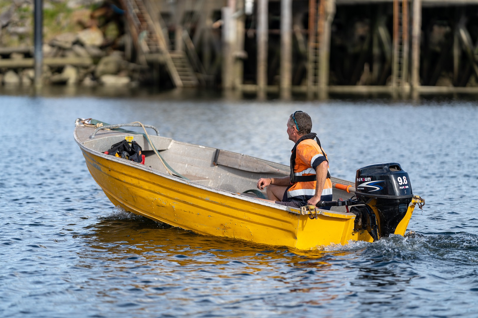 Man driving away on yellow boat