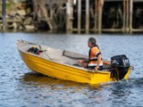 Man driving away on yellow boat